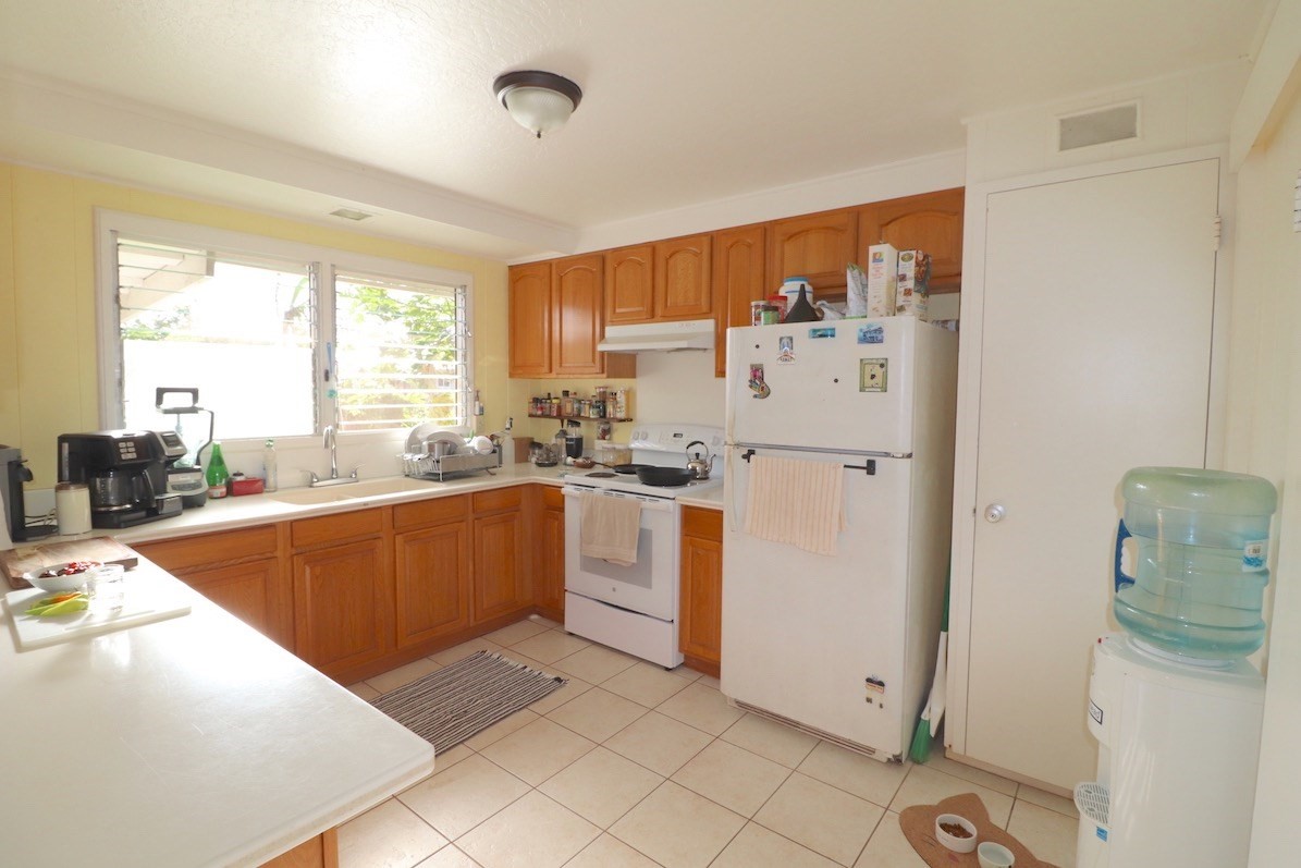 3434 Hailima Road Koloa, HI 96756 - Photo 5 of 13 a kitchen with a refrigerator a stove top oven and a large window