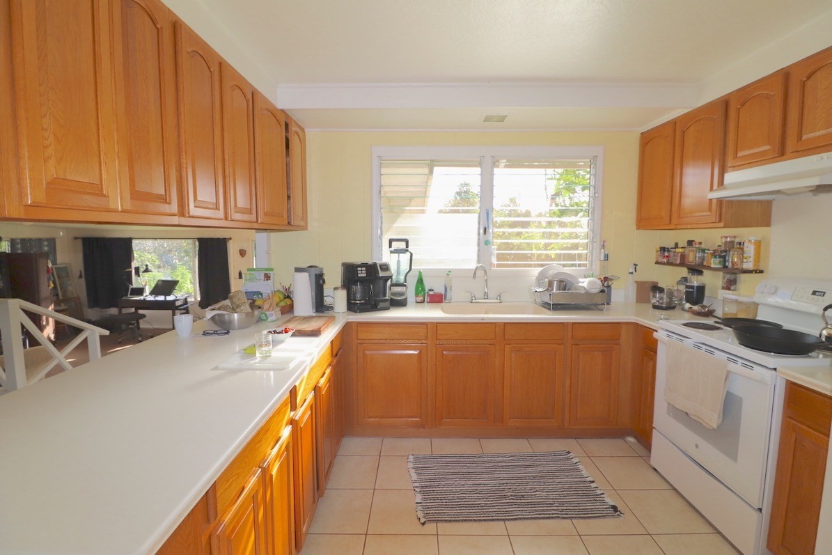 3434 Hailima Road Koloa, HI 96756 - Photo 6 of 13 a large kitchen with kitchen island a sink a counter top space and stainless steel appliances