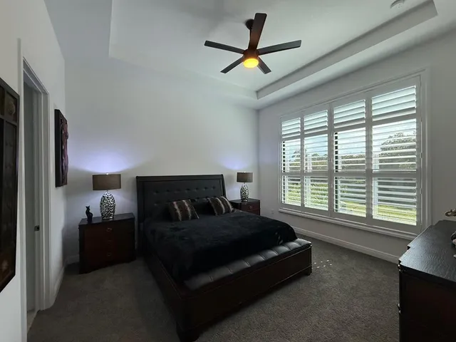 a bedroom with a bed and a large window