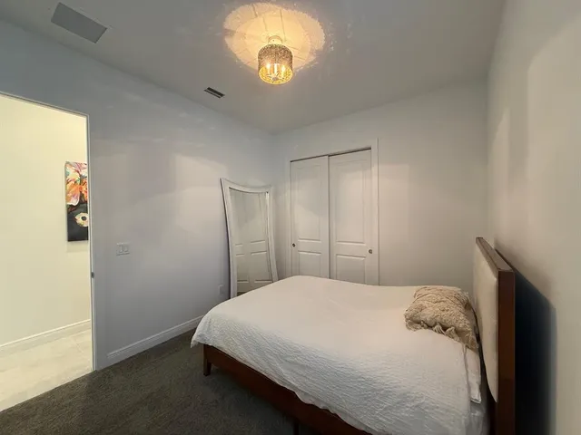 a bedroom with a bed and a chandelier
