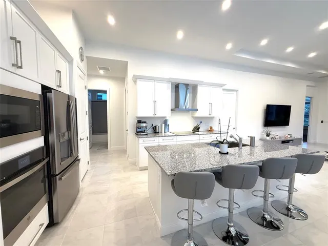 a kitchen with stainless steel appliances kitchen island granite countertop a sink and cabinets