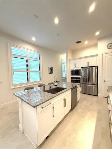 a kitchen with stainless steel appliances granite countertop a lot of counter space and a sink
