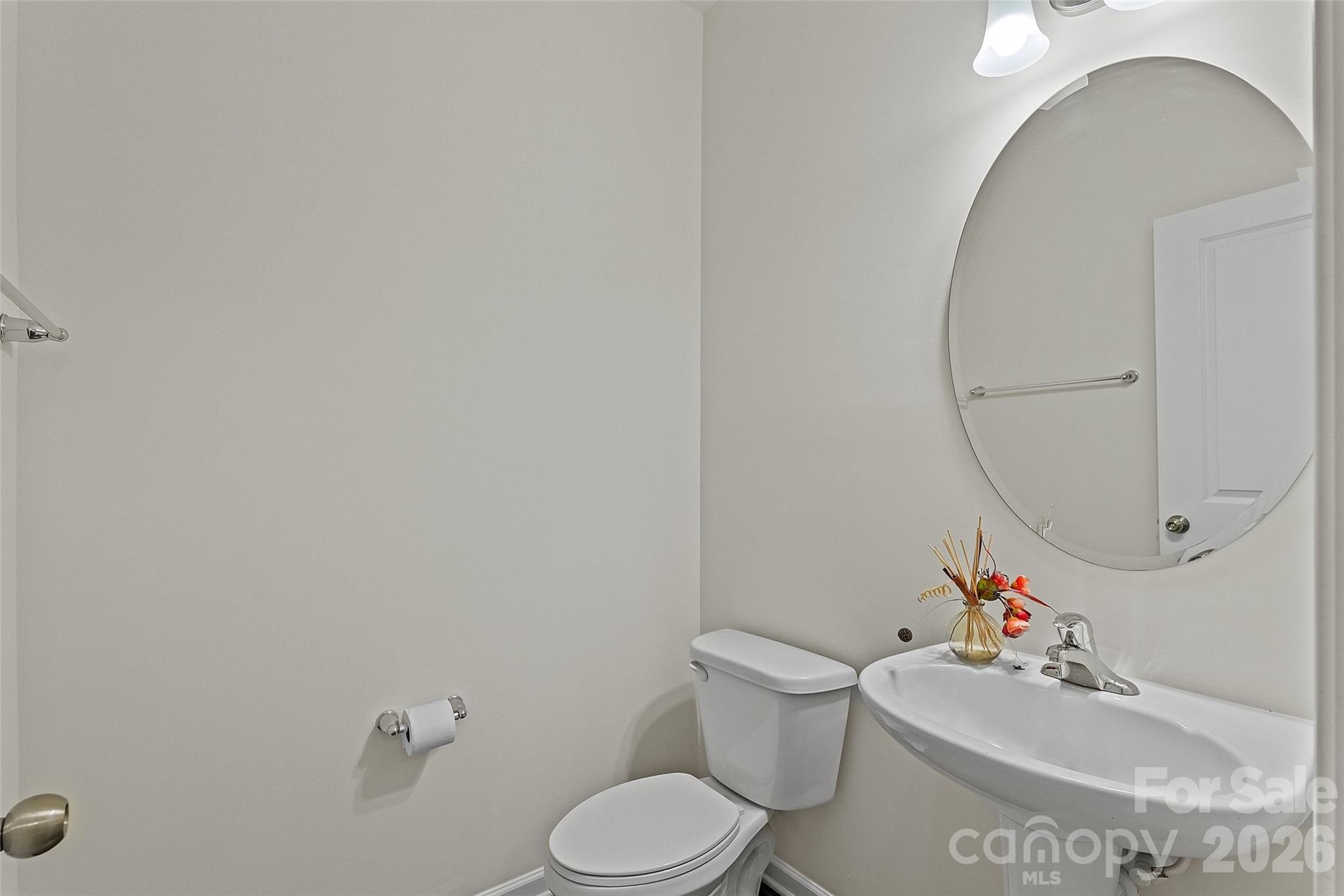 620 Amber Meadows Way Tega Cay, SC 29708 - Photo 5 of 27 a white toilet sitting next to a white sink and a mirror