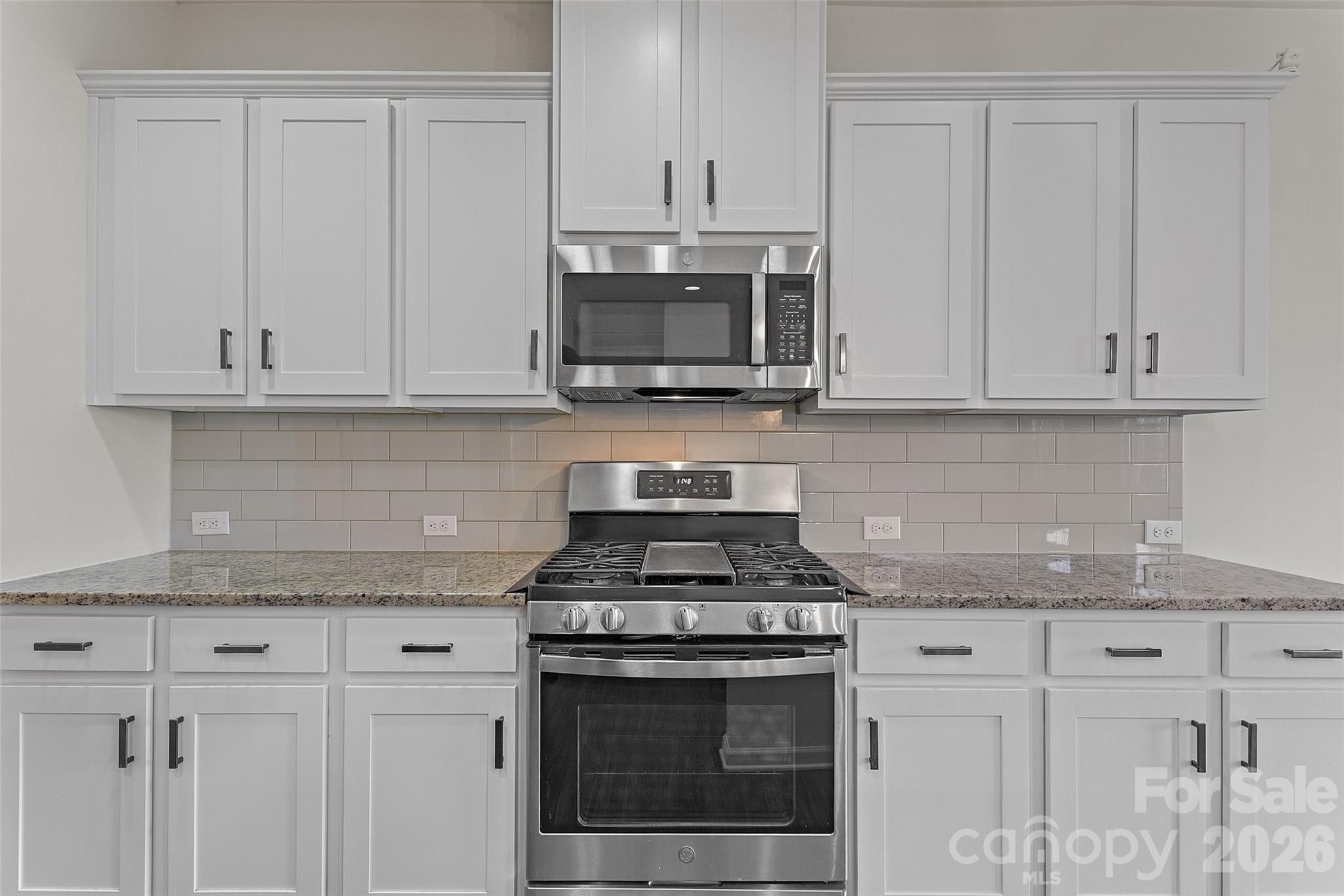620 Amber Meadows Way Tega Cay, SC 29708 - Photo 6 of 27 a kitchen with granite countertop white cabinets and a stove