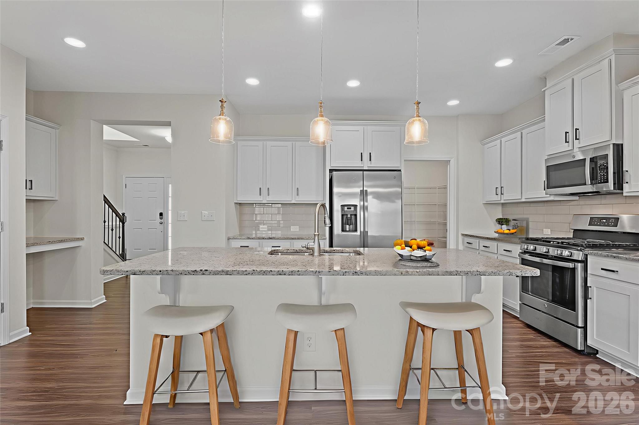620 Amber Meadows Way Tega Cay, SC 29708 - Photo 7 of 27 a kitchen with stainless steel appliances granite countertop a stove top oven a sink dishwasher and a refrigerator with wooden floor