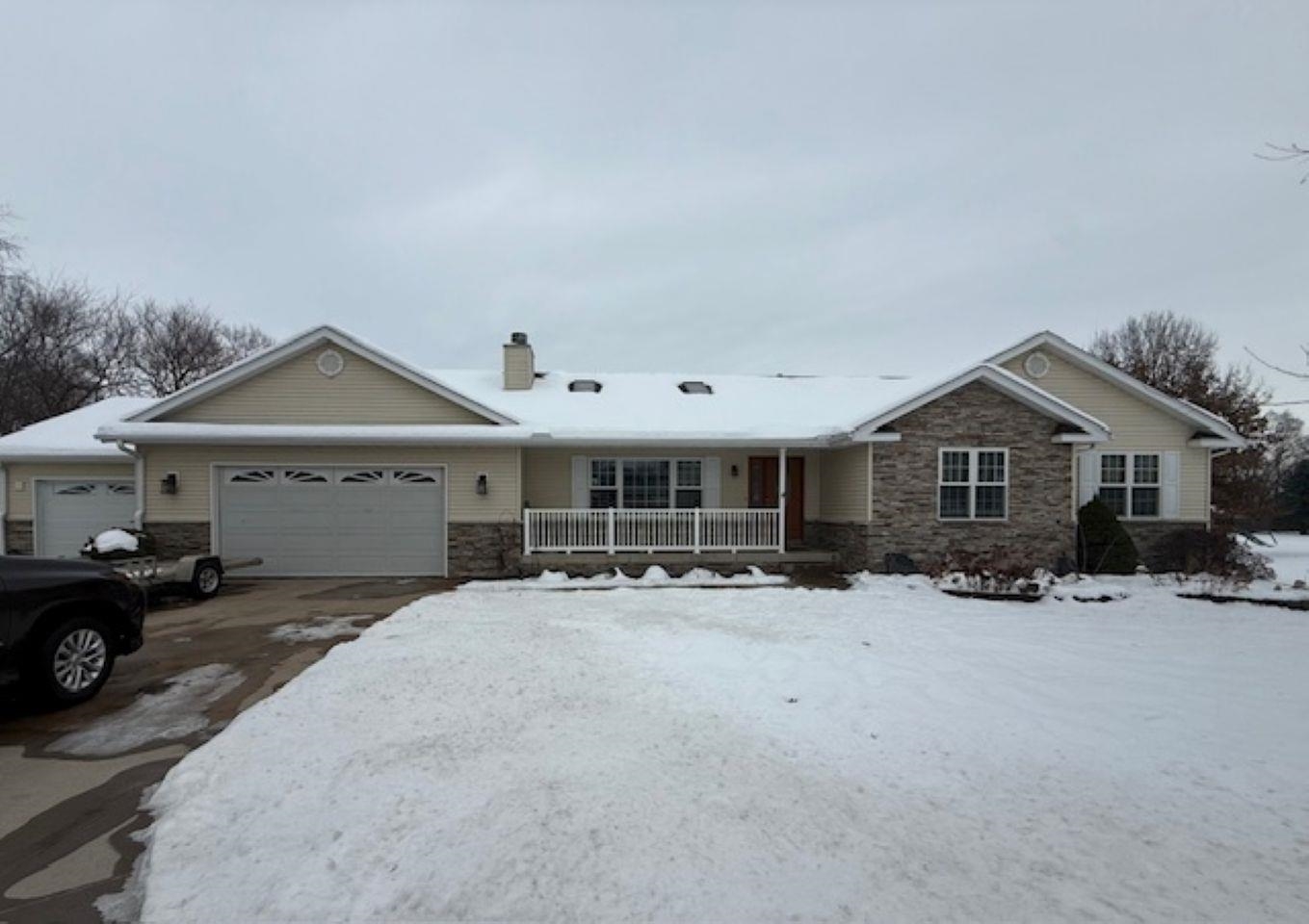 a front view of a house with a yard covered in snow