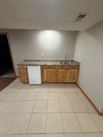 a view of kitchen with granite countertop and white cabinets