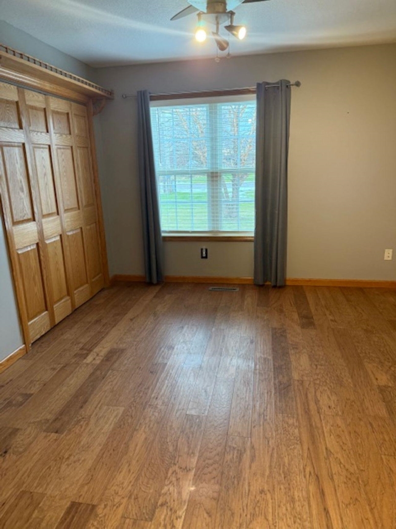 11501 Devils Creek Road Blue Grass, IA 52726 - Photo 6 of 9 an empty room with wooden floor and windows