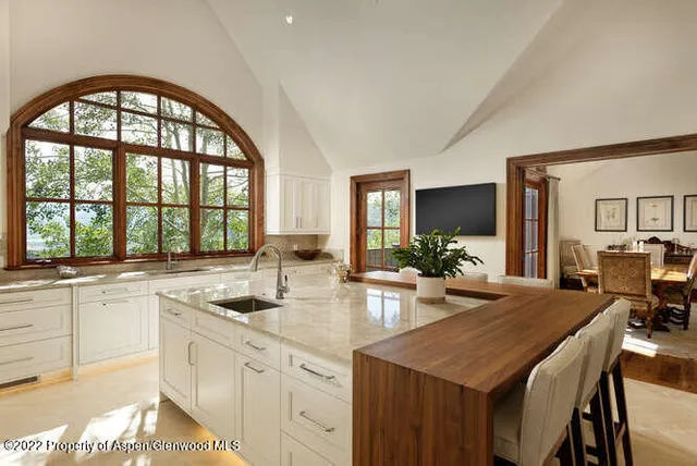 a kitchen with a stove a sink and chandelier