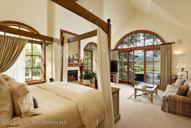 650 Pioneer Springs Ranch Road Aspen, CO 81611 - Photo 16 of 30 a bedroom with furniture a fireplace and a large window