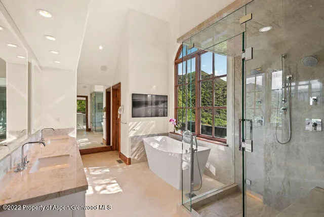 a bathroom with a tub shower and sink