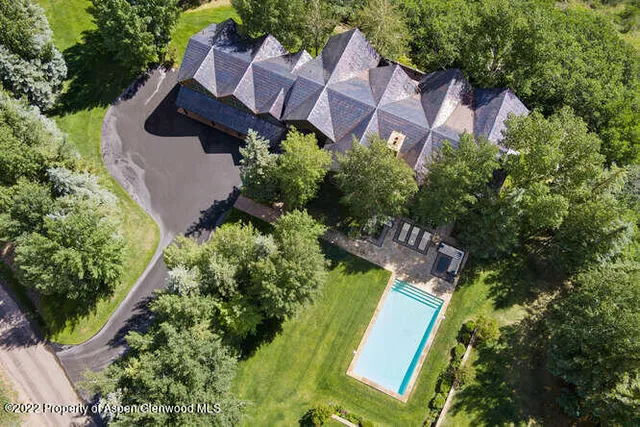 an aerial view of a house with garden space and street view