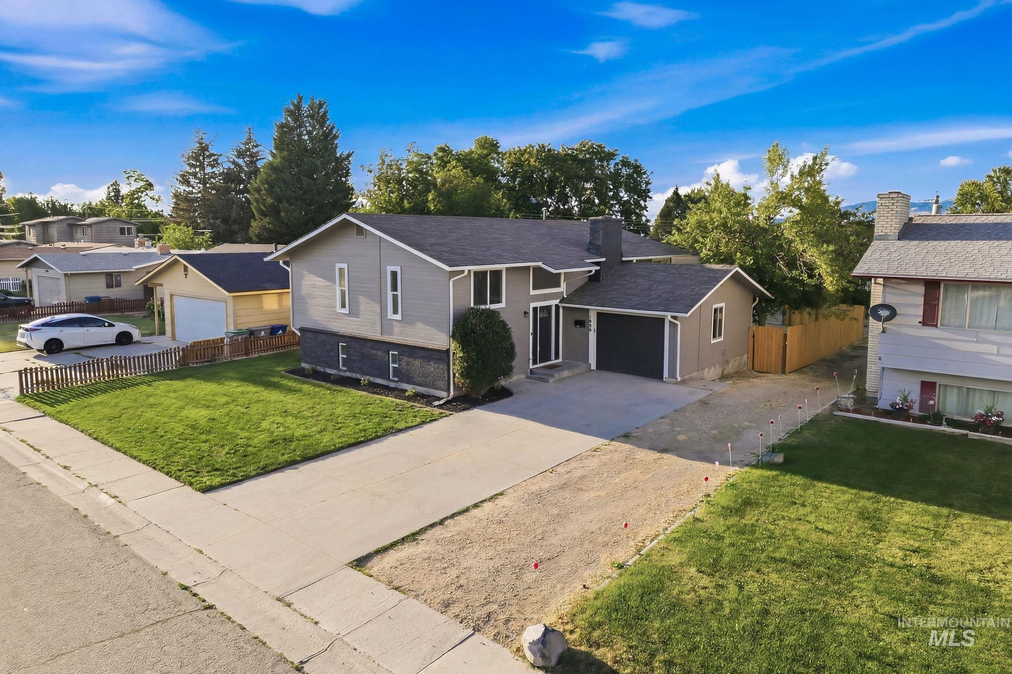 1990 Panama Street Boise, ID 83705 - Photo 3 of 50 Contemporary-style residence featuring a charcoal gray garage door, a prominent front entry, and a large manicured lawn