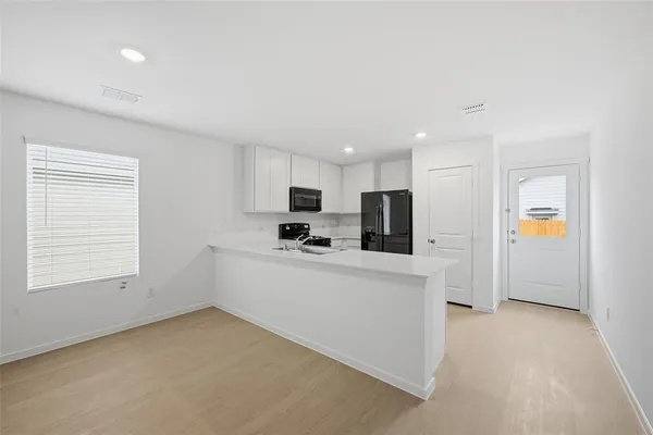 a view of kitchen with stainless steel appliances refrigerator stove microwave and sink