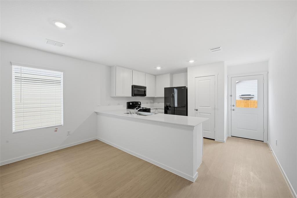 1034 Raintree Road Princeton, TX 75407 - Photo 4 of 21 a view of kitchen with stainless steel appliances refrigerator stove microwave and sink