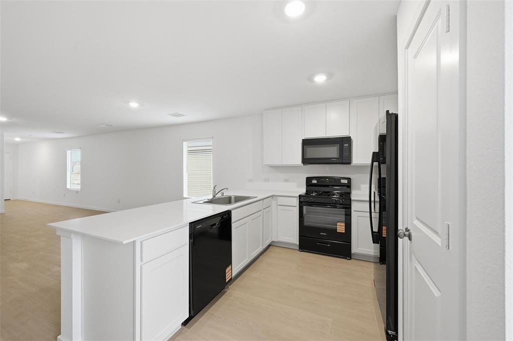 1034 Raintree Road Princeton, TX 75407 - Photo 6 of 21 a kitchen with a sink and stainless steel appliances