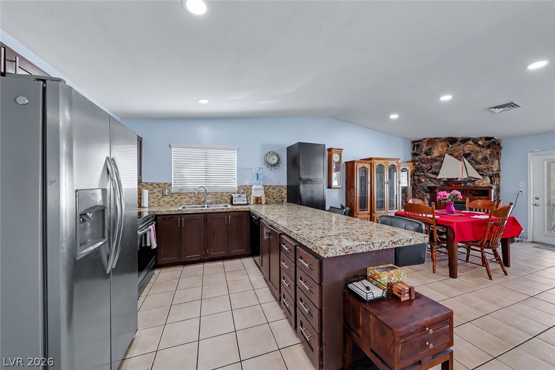 3107 Trueno Road Henderson, NV 89014 - Photo 15 of 37 Prepare meals and entertain guests in a large kitchen featuring granite countertops and an eat-in dining space.