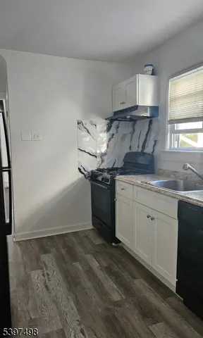 a kitchen with granite countertop cabinets stainless steel appliances and a sink