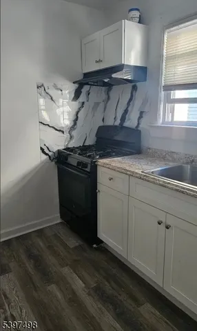a kitchen with granite countertop a stove and a sink