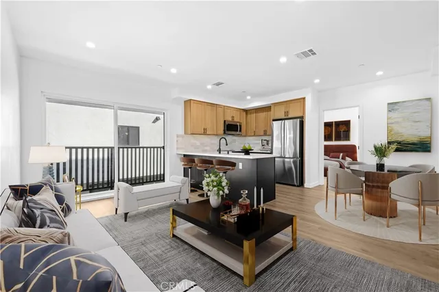 a living room with furniture kitchen view and a large window