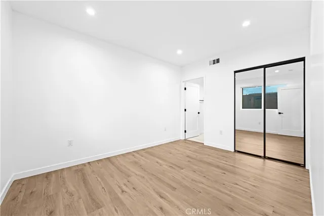 an empty room with wooden floor and door
