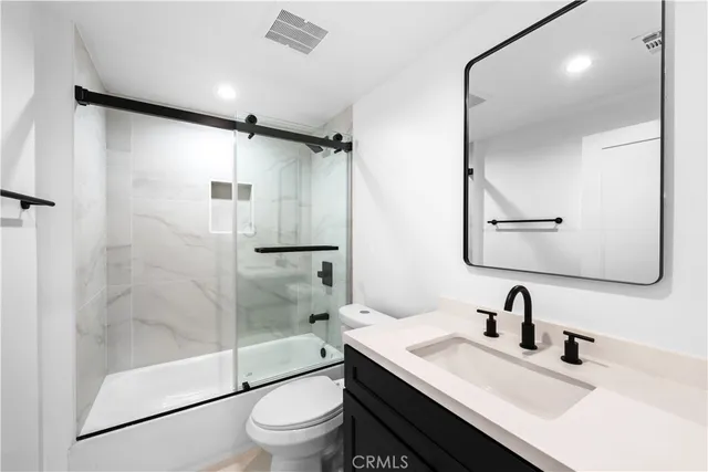 a bathroom with a granite countertop sink toilet and shower