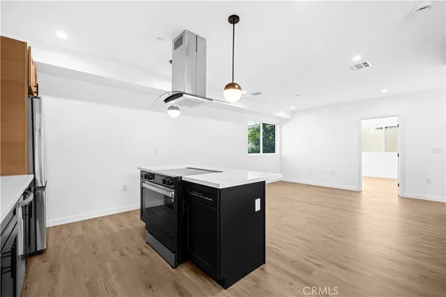 a kitchen with a stove and a wooden floor