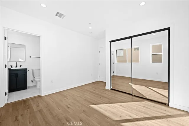 a view of a big room with wooden floor and windows