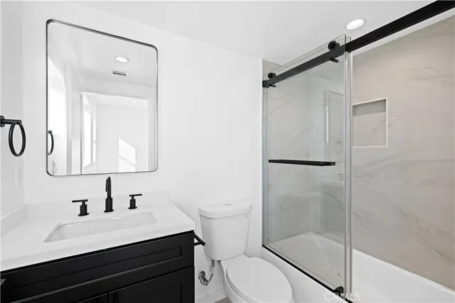 a bathroom with a sink vanity mirror and toilet