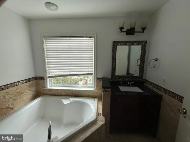 a bathroom with a bathtub and a window