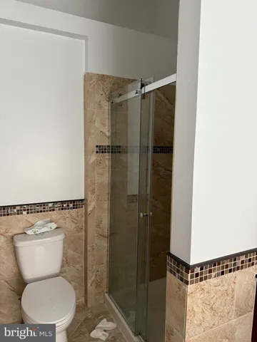 a bathroom with a toilet and a shower