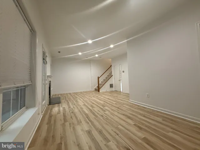 a view of empty room with wooden floor