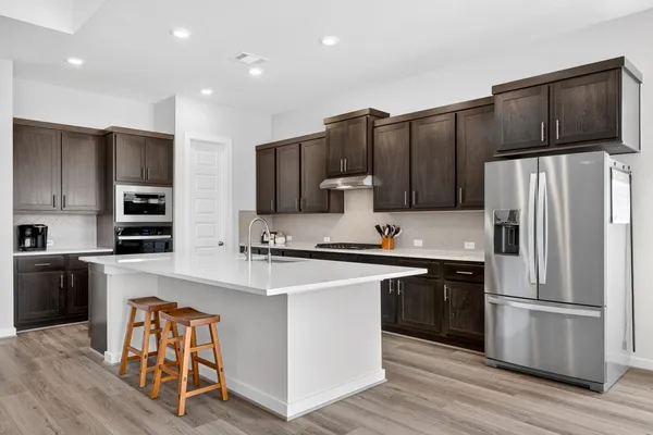 a kitchen with stainless steel appliances granite countertop a refrigerator stove microwave and sink