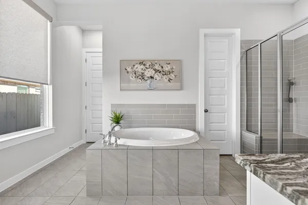 a bathroom with a tub sink and mirror