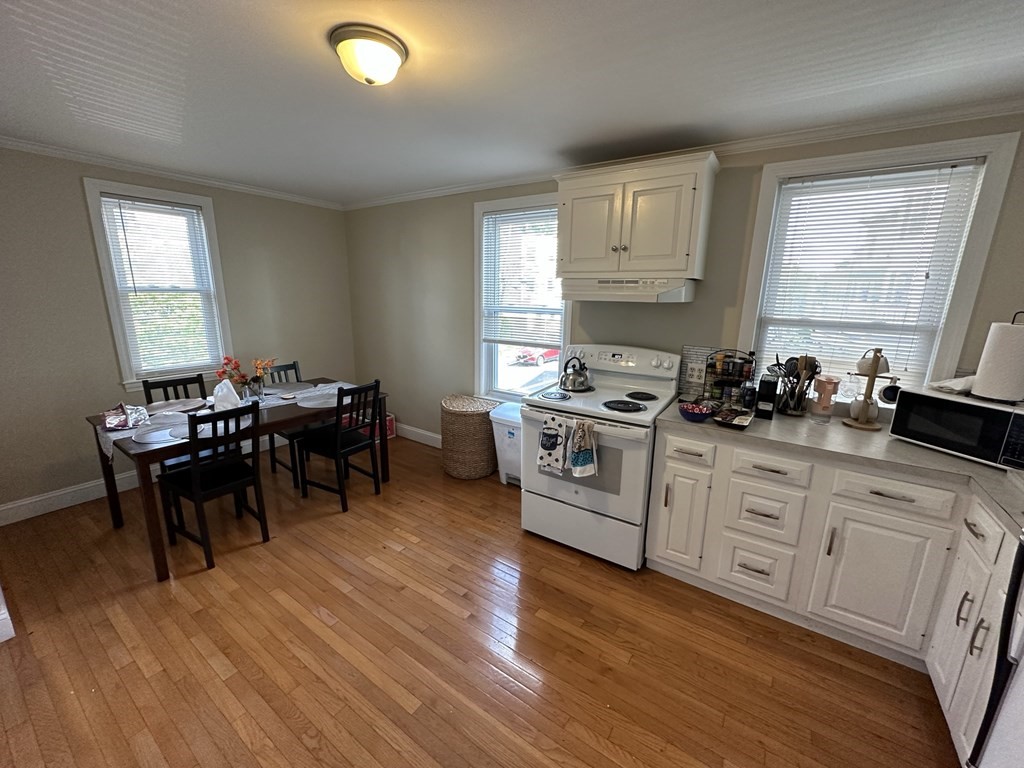 438 Washington Street, Unit 2 Boston, MA 02135 - Photo 4 of 12 a kitchen with furniture wooden floor and a window