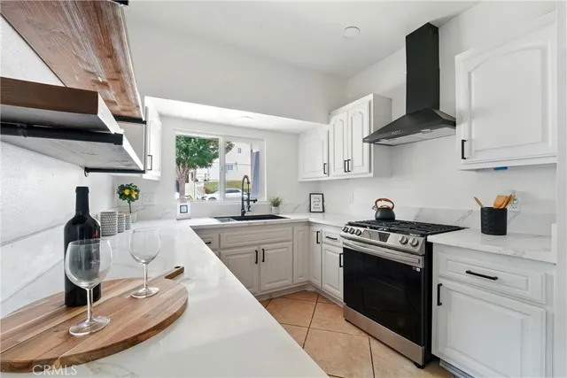a kitchen with stainless steel appliances a stove a sink and white cabinets