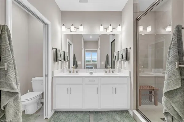 a bathroom with a double vanity sink mirror and shower