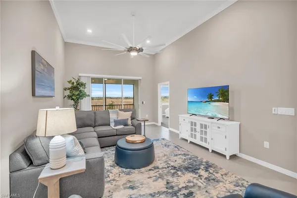 a living room with furniture a window and a flat screen tv