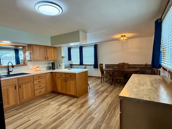 a large kitchen with a lot of counter space and wooden floor