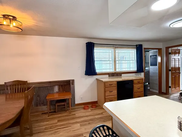 a kitchen with stainless steel appliances kitchen island granite countertop a table chairs and a wooden cabinets