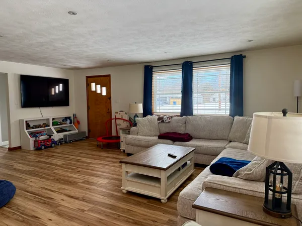 a living room with furniture flat screen tv and a large window