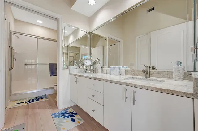 a bathroom with a double vanity sink mirror and shower