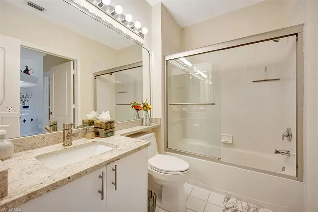a bathroom with a granite countertop sink a toilet and shower
