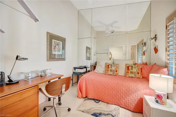 a bedroom with two bed and a lamp on the dresser