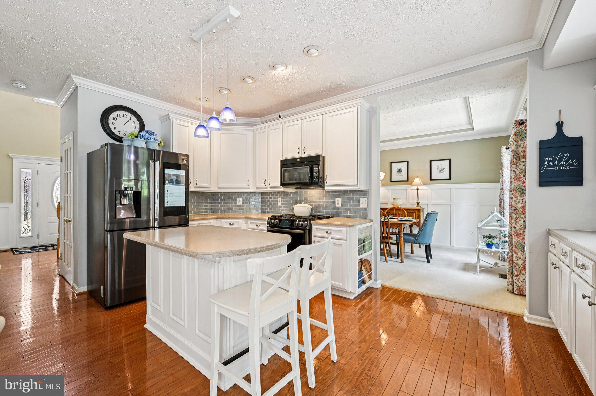 3137 Pyramid Circle Manchester, MD 21102 - Photo 5 of 55 a kitchen with stainless steel appliances kitchen island granite countertop a refrigerator a stove top oven a sink dishwasher and white cabinets with wooden floor