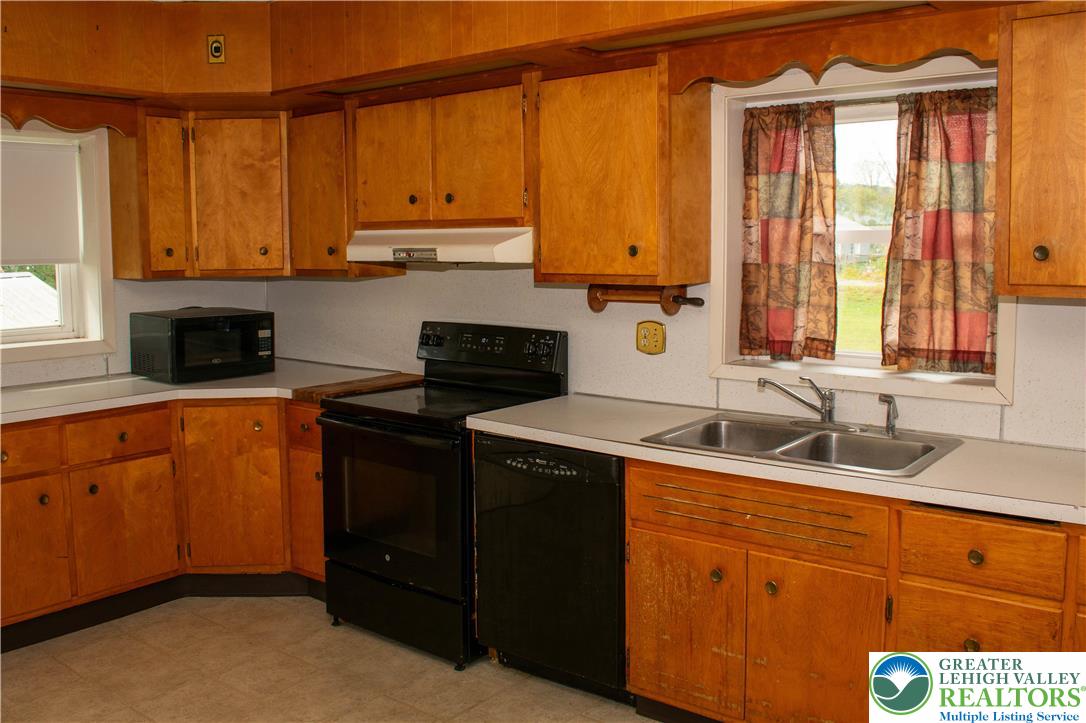 3914 Mauch Chunk Road Coplay, PA 18037 - Photo 2 of 8 a kitchen with stainless steel appliances granite countertop a sink stove and cabinets