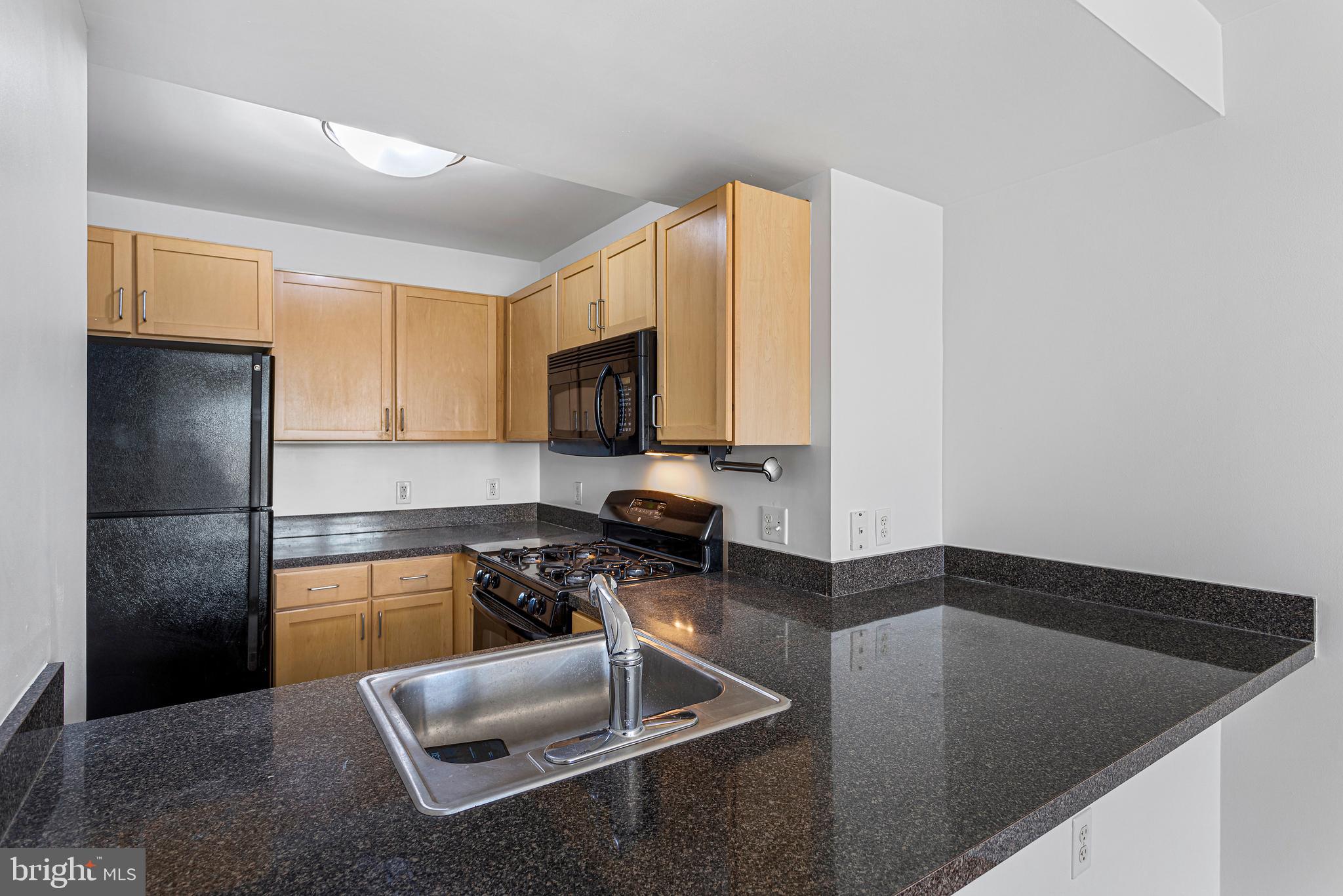 800 4th Street Southwest, Unit S425 Washington, DC 20024 - Photo 12 of 27 a kitchen with a sink a counter top space cabinets and stainless steel appliances