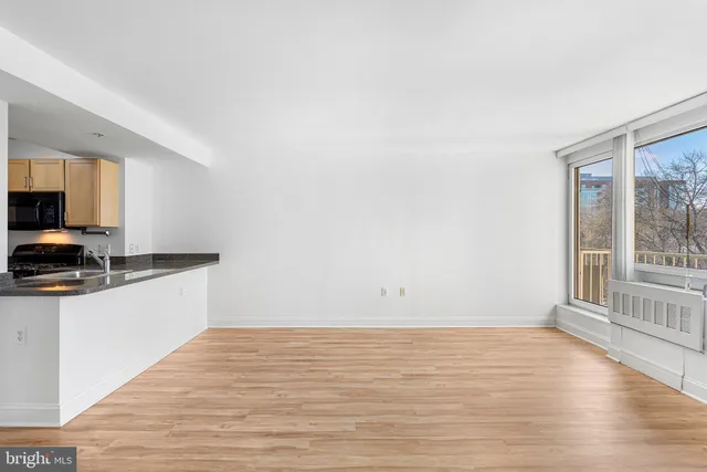 a view of a kitchen with wooden floor and electronic appliances