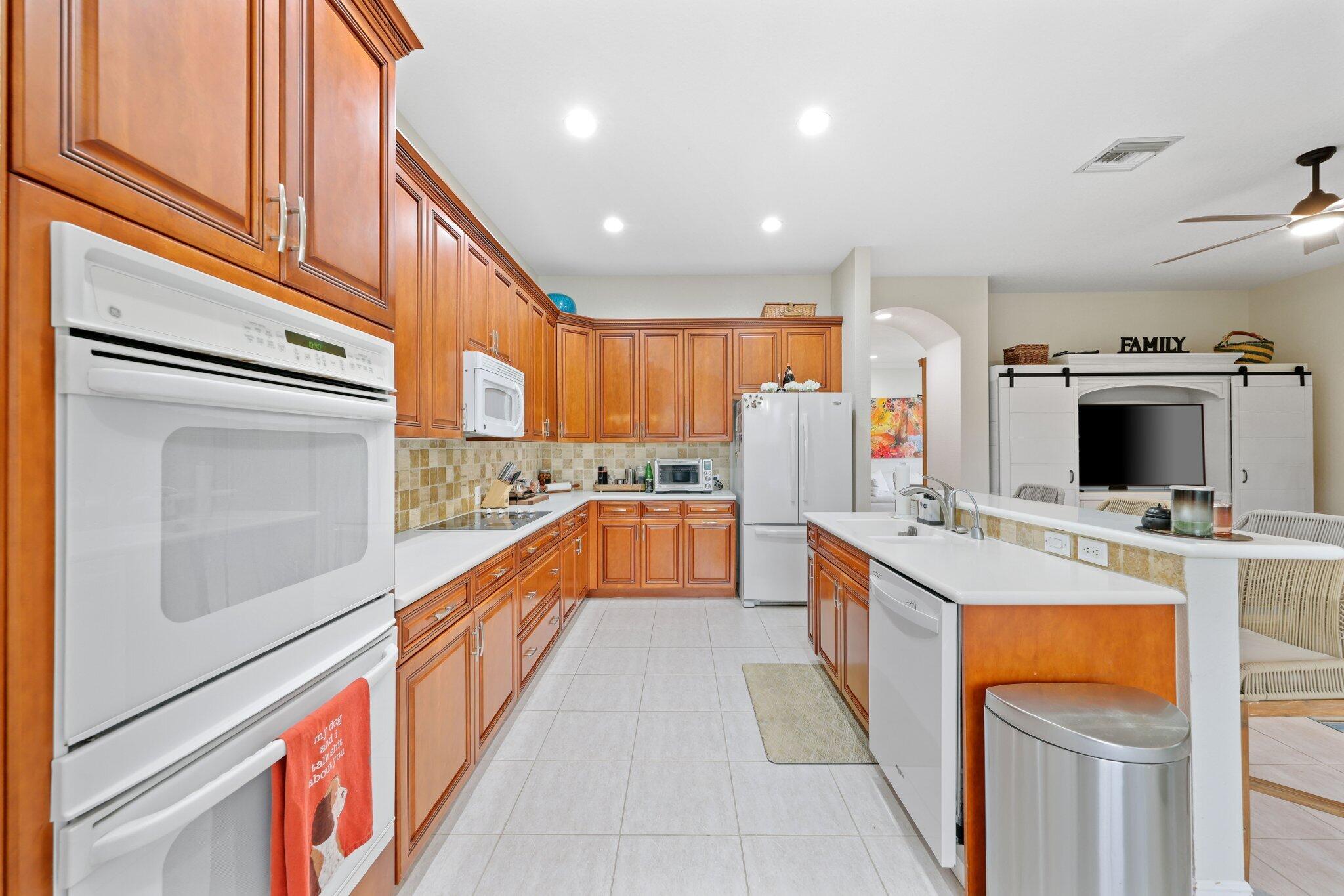 19090 Skyridge Circle Boca Raton, FL 33498 - Photo 15 of 70 a large kitchen with stainless steel appliances kitchen island granite countertop a refrigerator a stove and a sink with cabinets