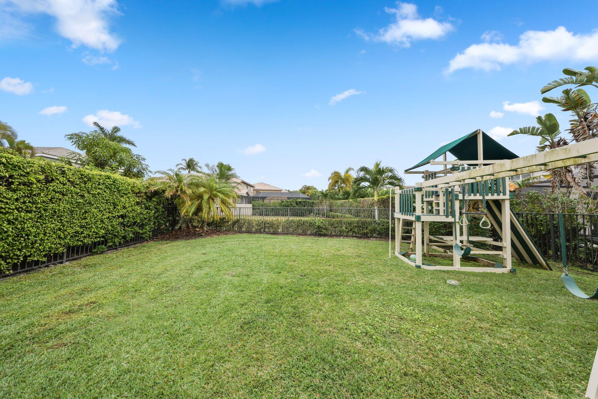 19090 Skyridge Circle Boca Raton, FL 33498 - Photo 47 of 70 a view of a backyard with plants and a slide
